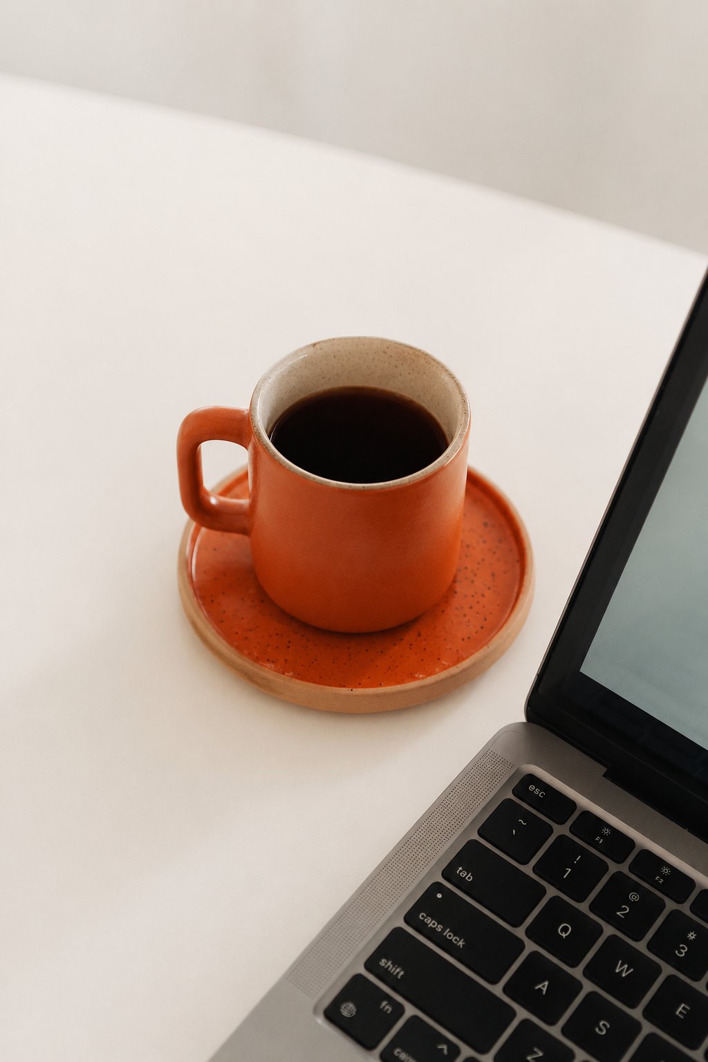 Espresso cup beside a laptop